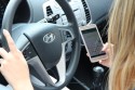 Kierowca ze smartfonem w ręku podczas jazdy