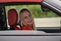 Uśmiechnięta kobieta w samochodzie za kierownicą