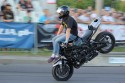 Jazda na motorze w pozycji siedzącej na baku na przednim kole z nogami do przodu